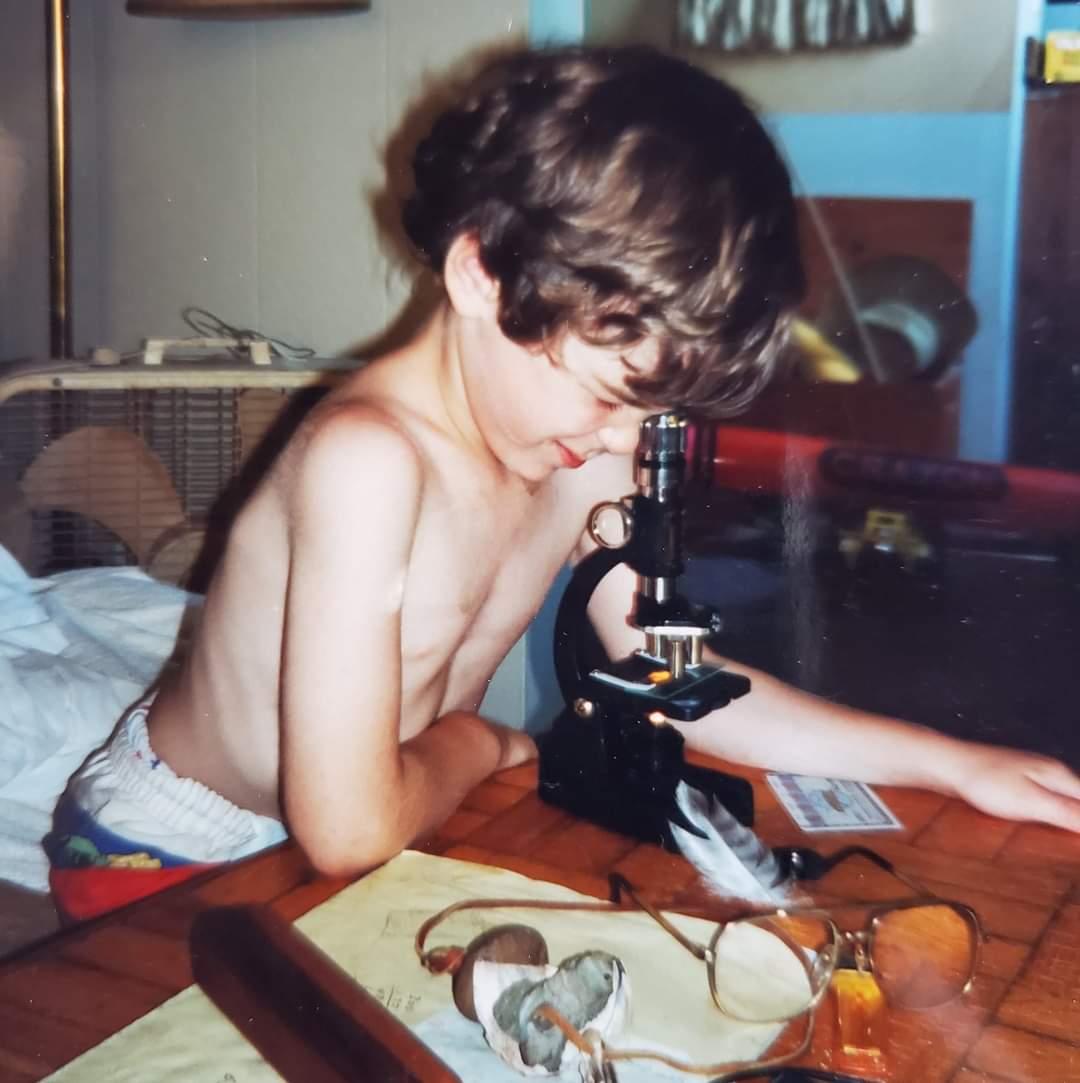 Justin Zoll, der Gewinner des Global Image of the Year (IOTY) 2020 der Region Americas, als Kind mit einem Mikroskop