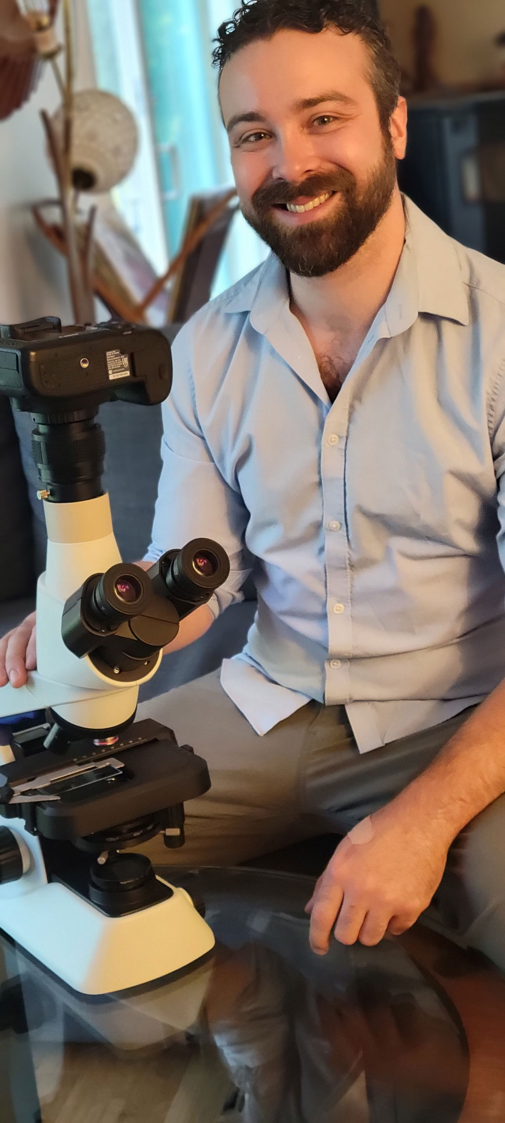 Justin Zoll, der Gewinner des IOTY 2020 der Region Americas, mit seinem Preis, einem aufrechten CX23 Mikroskop 